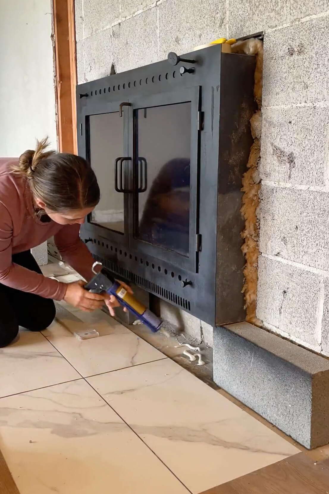 Using liquid nails to glue down a hearth stone.